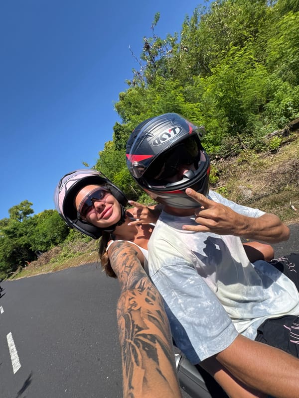 Two helmeted riders photographed on motorcycle in Denpasar