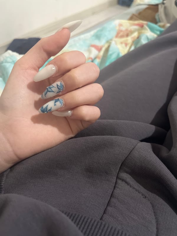 Person shows off white artificial nail manicure in Vidin