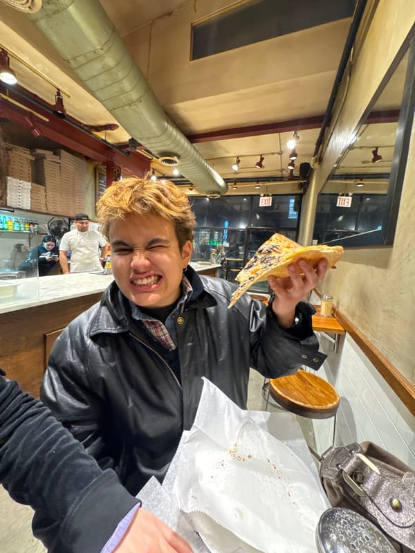Person enjoys pizza slice in New York building