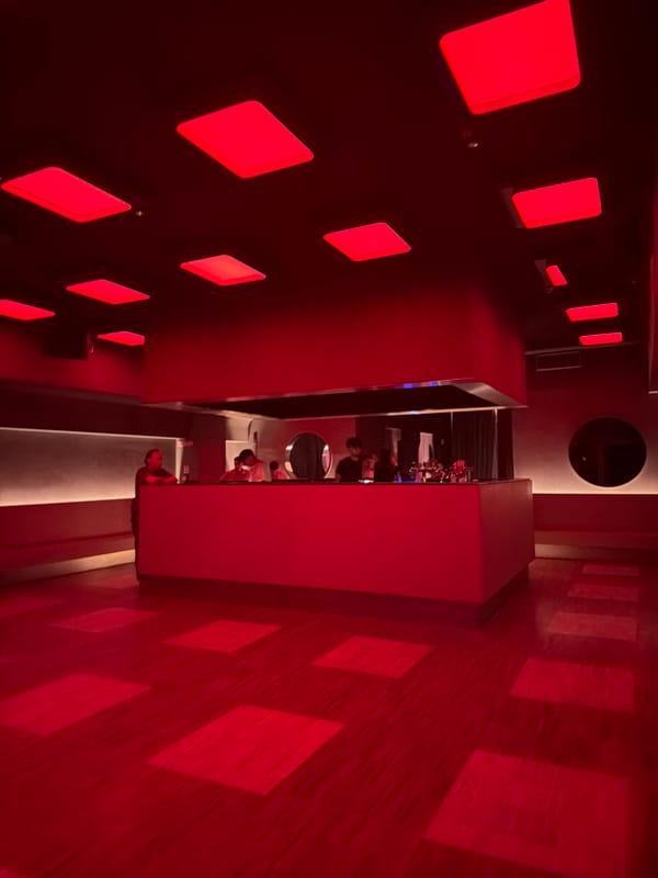 Inside a Milan nightlife venue with signature red lighting