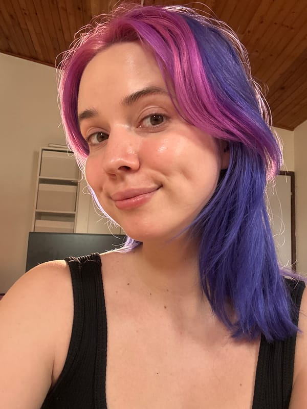 Person with colorful hair photographed smiling indoors in Zagreb