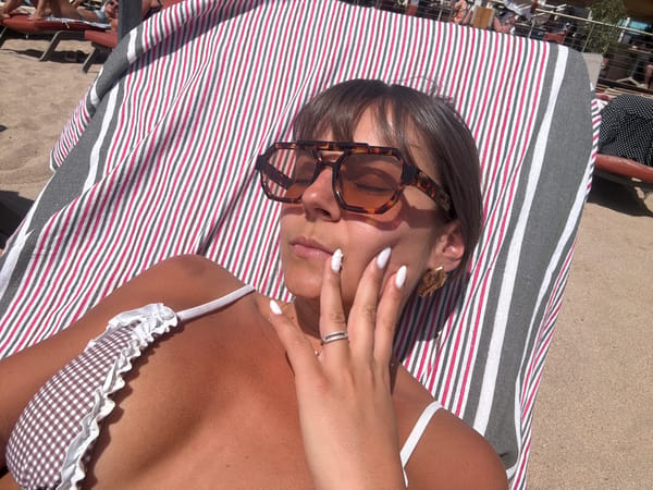 Beach scene captured in Cannes with sunbather, pier visitors