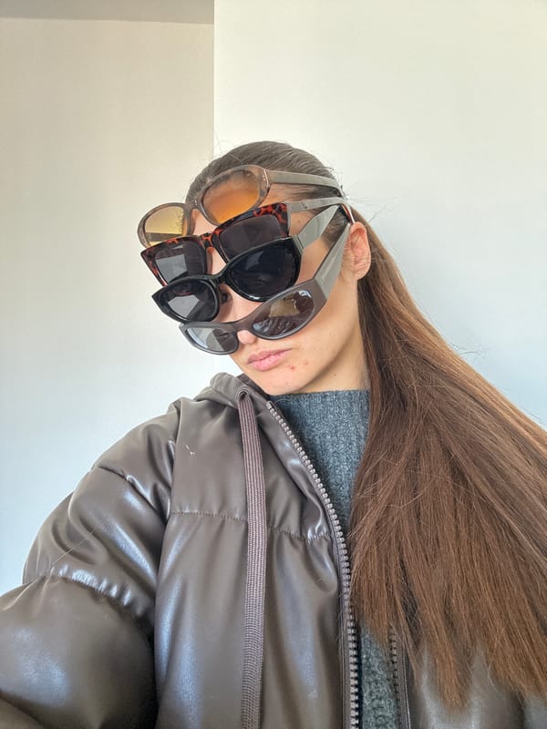 Copenhagen resident poses with stacked sunglasses in playful photo session