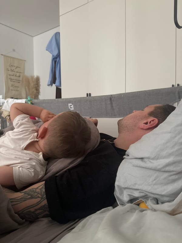 Father and child share quiet bedroom moment