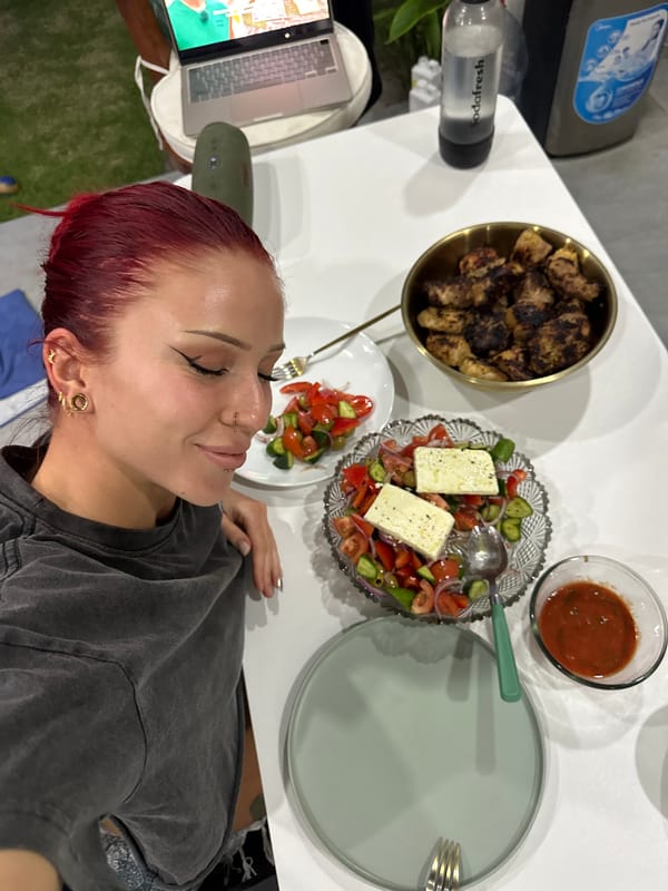 Woman enjoys Greek meal with laptop in North Kuta