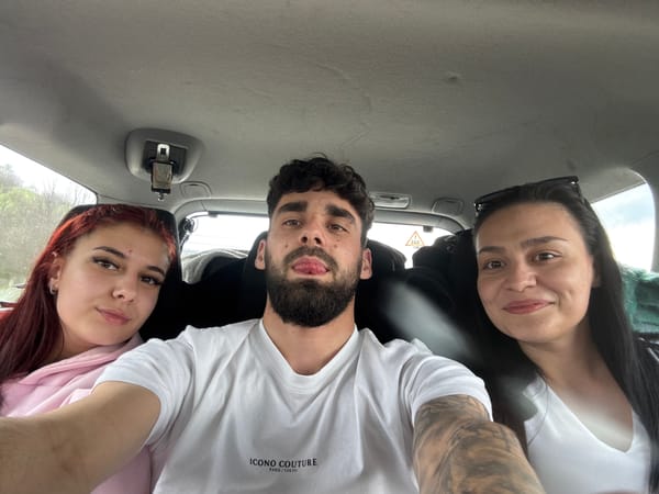 Three people photographed from vehicle, bearded man in designer shirt
