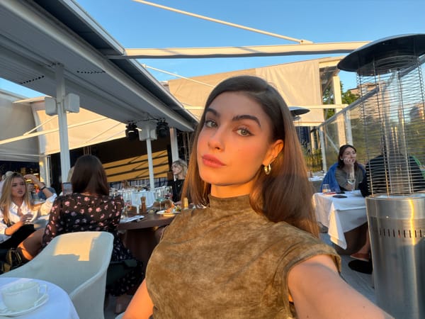 Woman takes selfie at Moscow restaurant patio during golden hour