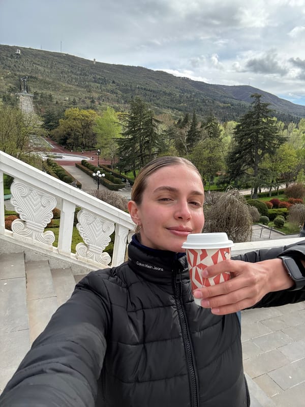 Woman takes selfie on ornate stairs in Tbilisi