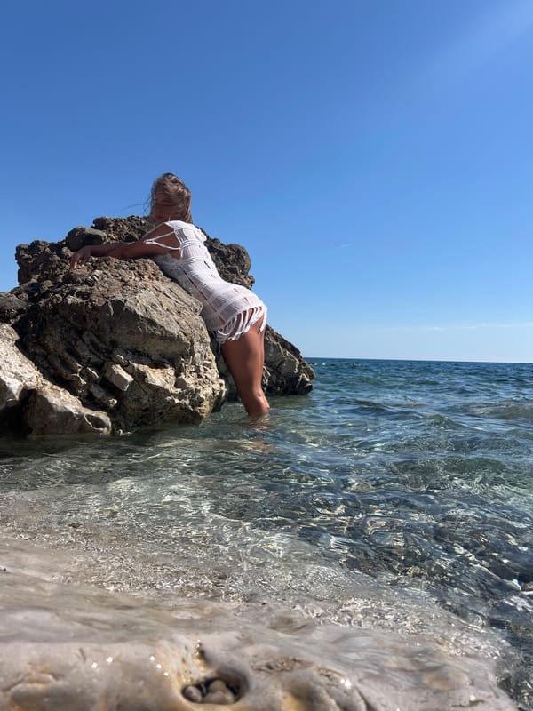 Woman sunbathes on rocky beach in Prijevor, Montenegro