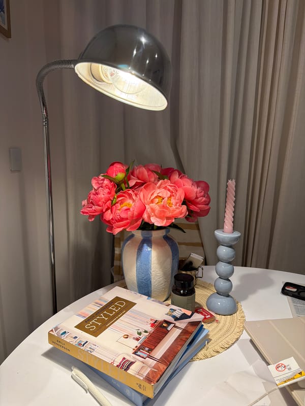 Coral peonies arranged in striped vase captured in Gangloff