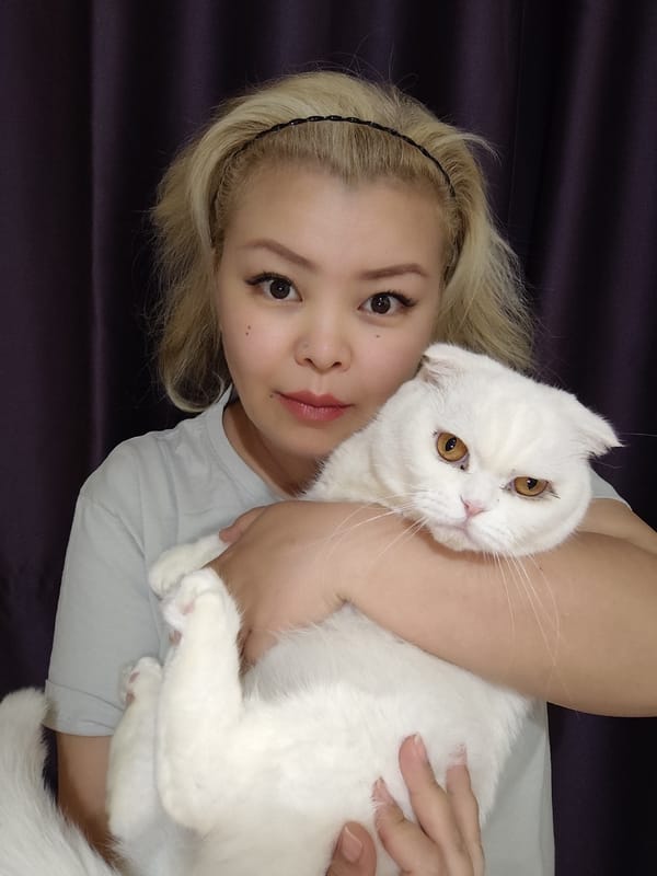 Woman and white Scottish Fold cat share quiet indoor moments