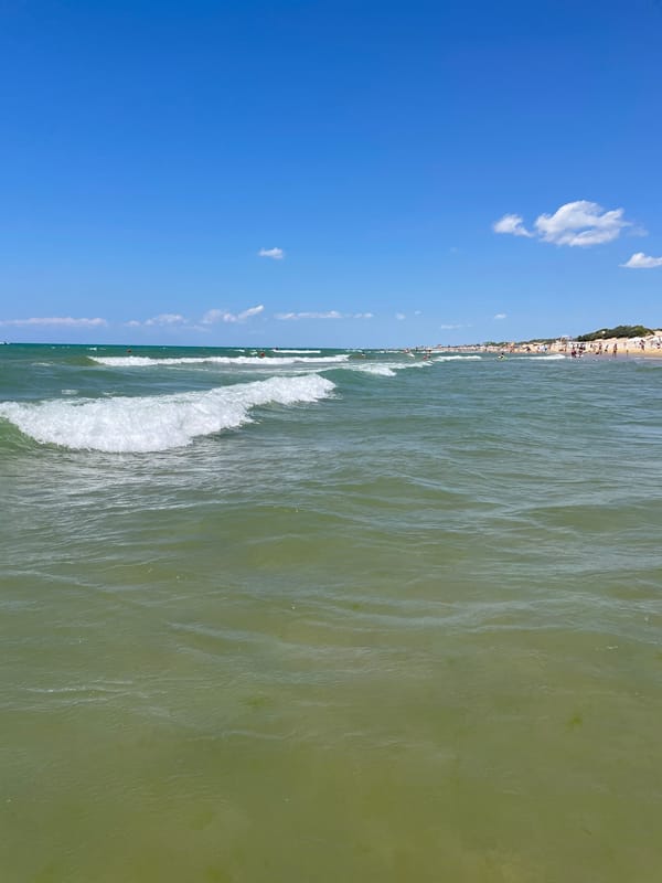 Sunny day at Anapa beach, calm green water and gentle waves
