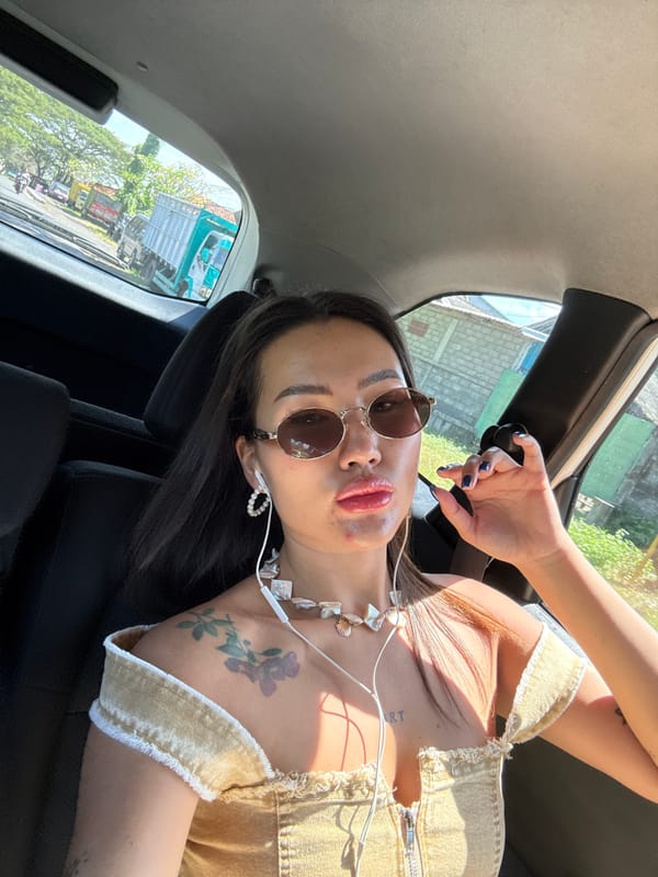 Woman photographed in passenger seat wearing gold accessories, Dawan