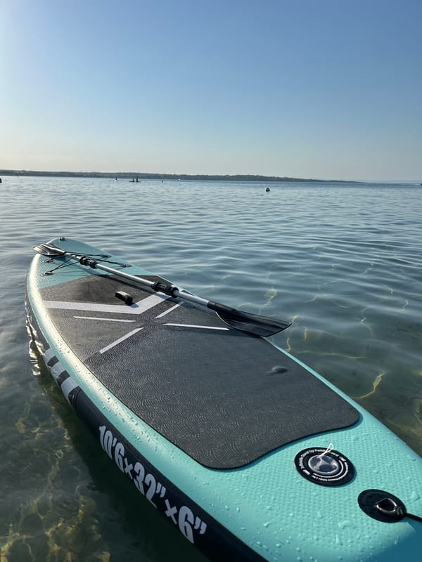Calm tropical beach day with paddleboards and a speedboat