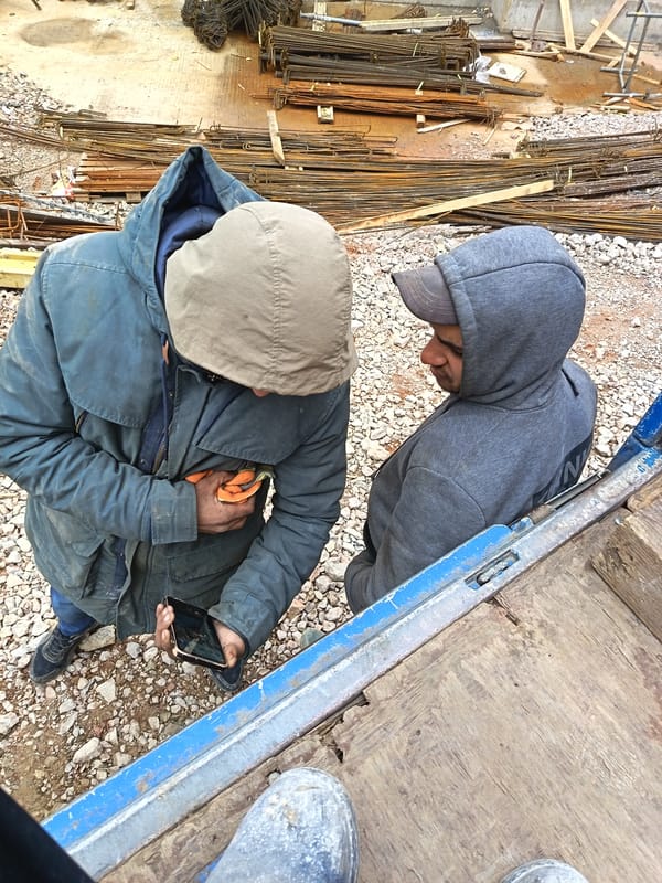 Construction workers take phone break at Sofia building site