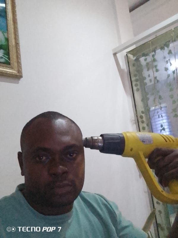 Man uses heat gun indoors in Gwarinpa, Nigeria