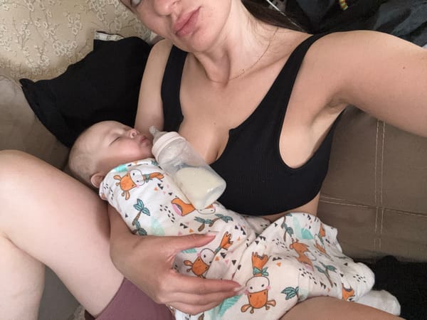 Mother feeds baby with bottle in early morning Sochi