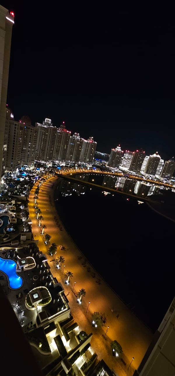 Night aerial of The Pearl-Qatar's glowing waterfront promenade