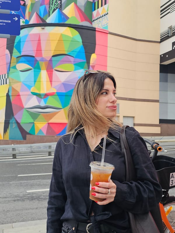 Street life clusters around a bold geometric mural in central Moscow