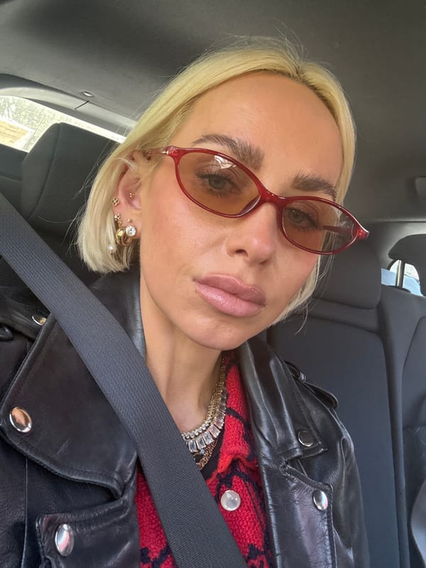 Woman in red sunglasses, leather jacket observed in Milan car