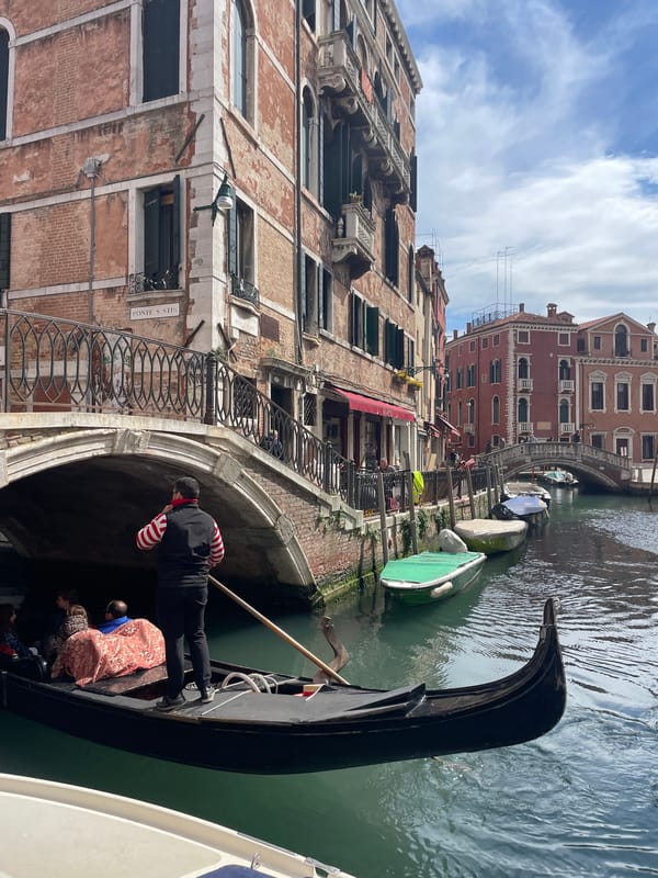 Gondola carries passengers through Venice canal