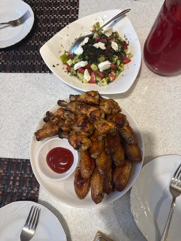 Chicken wings, dumplings, and drinks set out for a meal