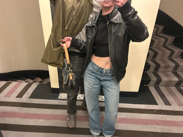 Person poses for photo in hallway wearing casual outfit