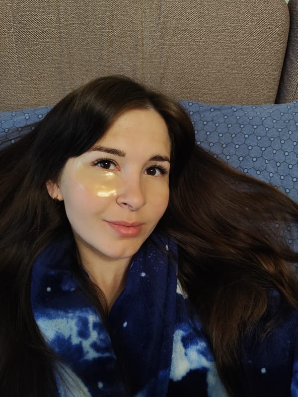 Woman in gold eye patch rests on couch in Russia