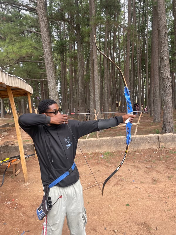 Man practices archery at outdoor range in Jos, Nigeria