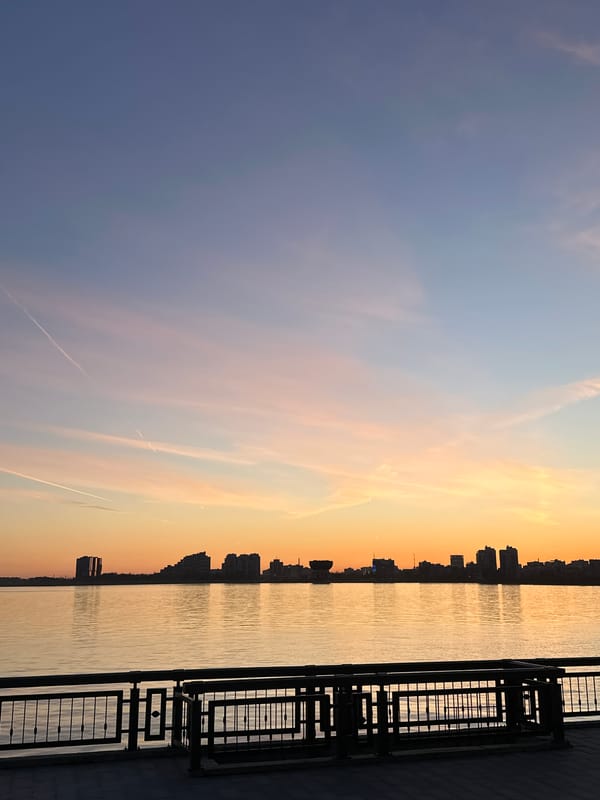 Young man poses on Kazan waterfront during sunset