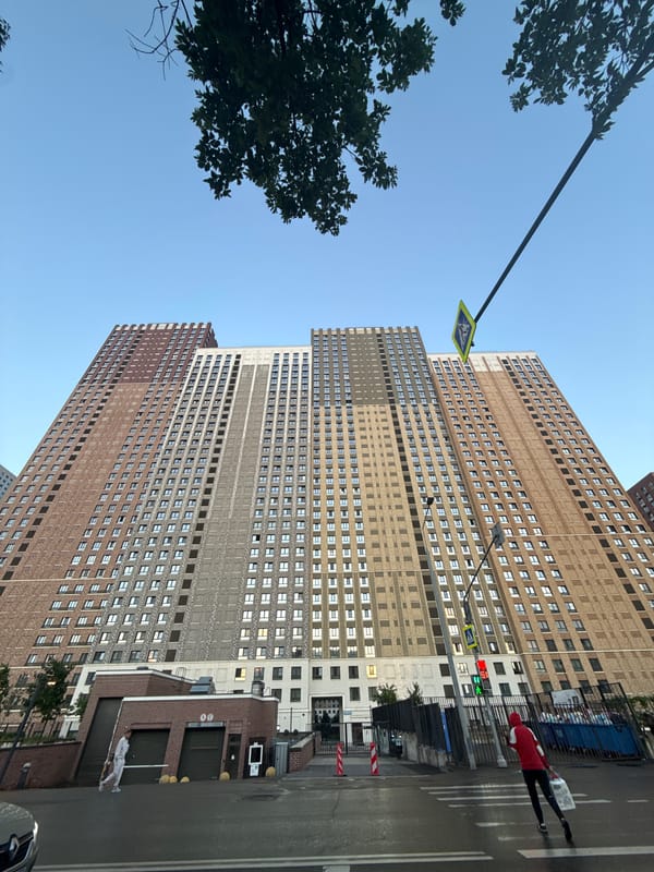 Tall brick residential tower rises against clear Moscow sky