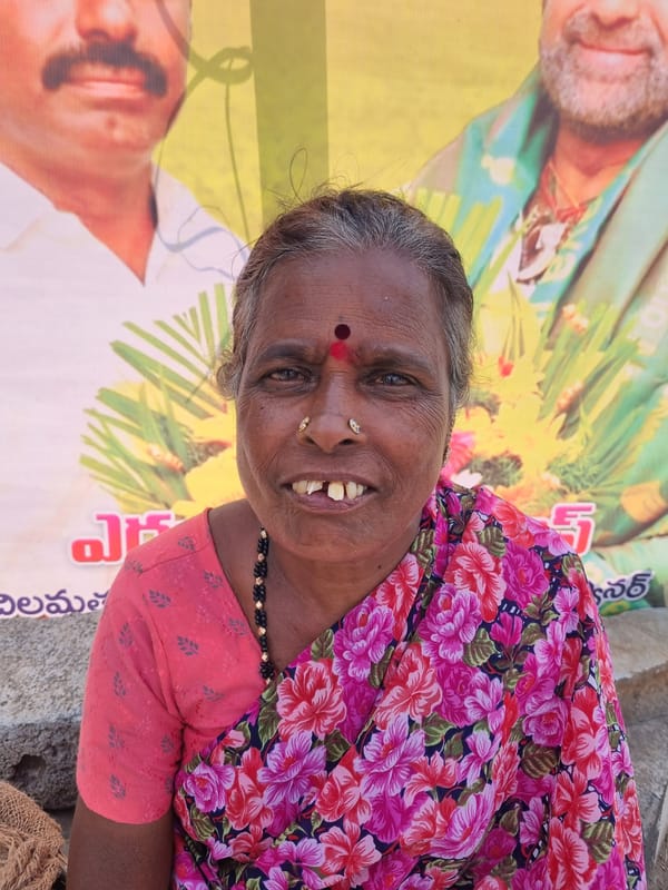 Woman poses near campaign poster at Indian checkpoint