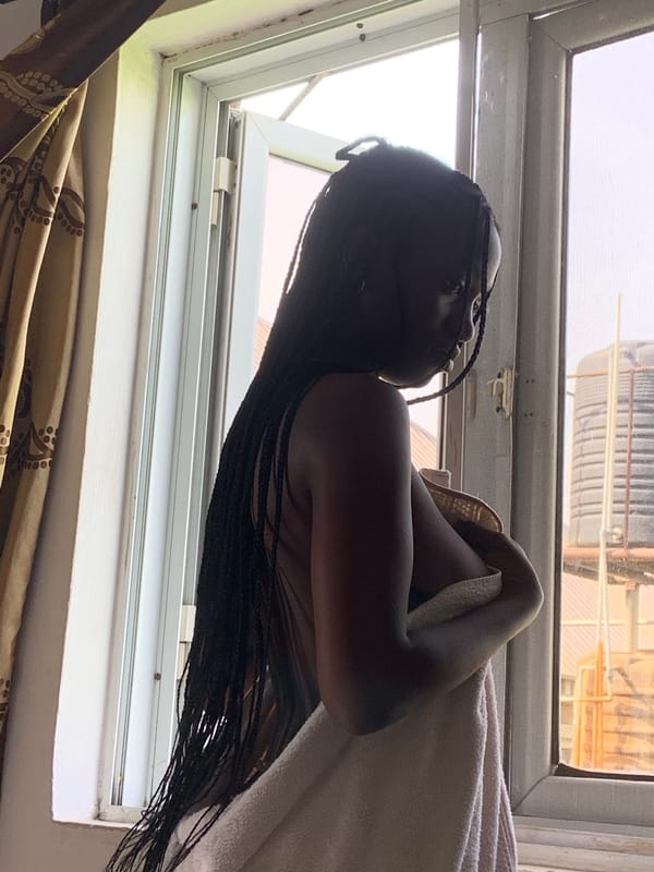 Woman with braided hair rests indoors in Iranla, Nigeria