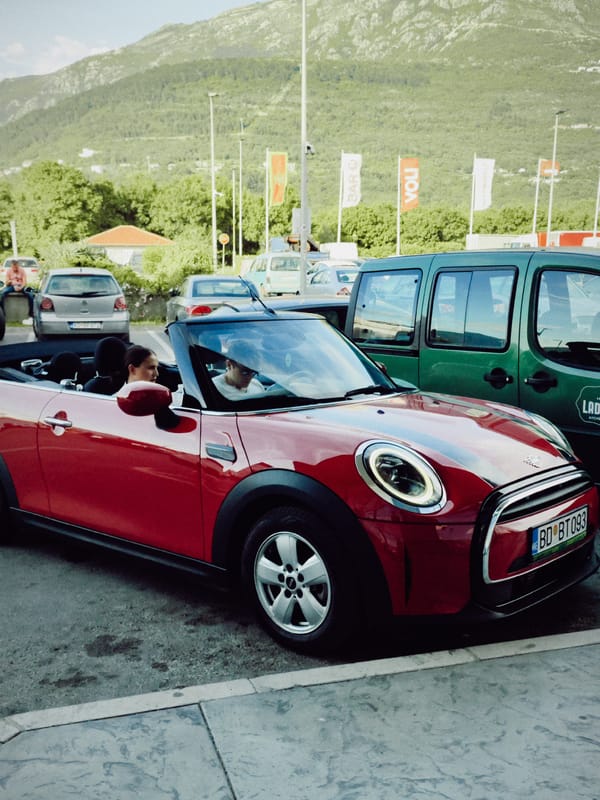 Red Mini Cooper, cyclists gather in Dub parking lot