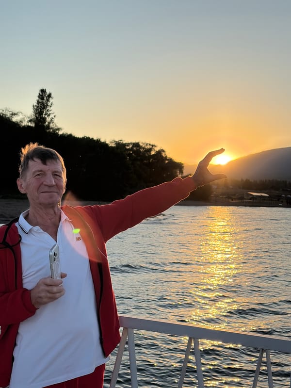 Afternoon at a scenic waterfront with mountains, flowers, and sunset views