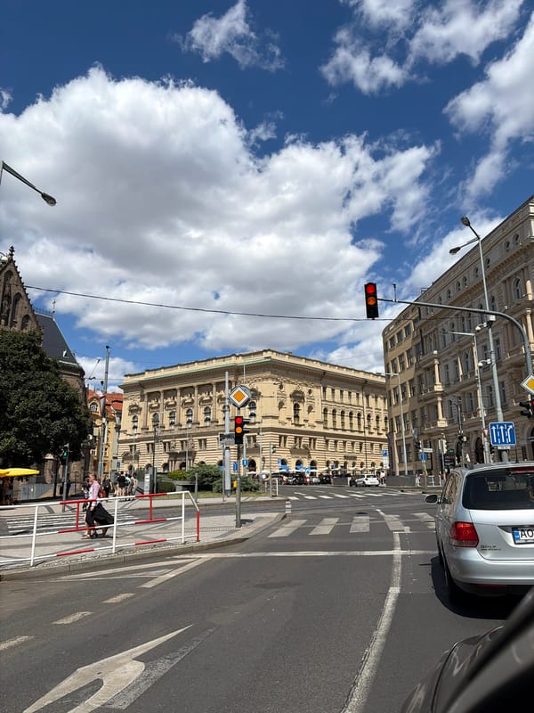 Sunny afternoon at a Prague street corner near a brick church