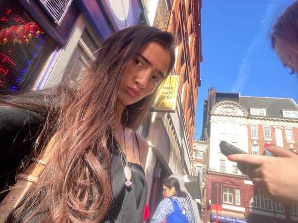 Woman takes selfie near sushi shop in London Chinatown