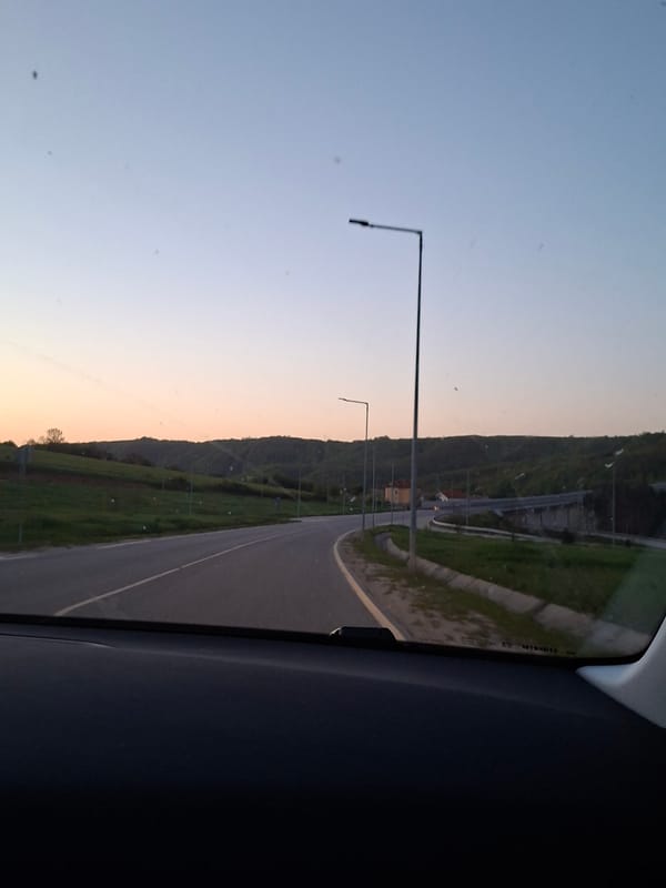 Vehicle travels illuminated road during twilight in Gabrovo, Bulgaria