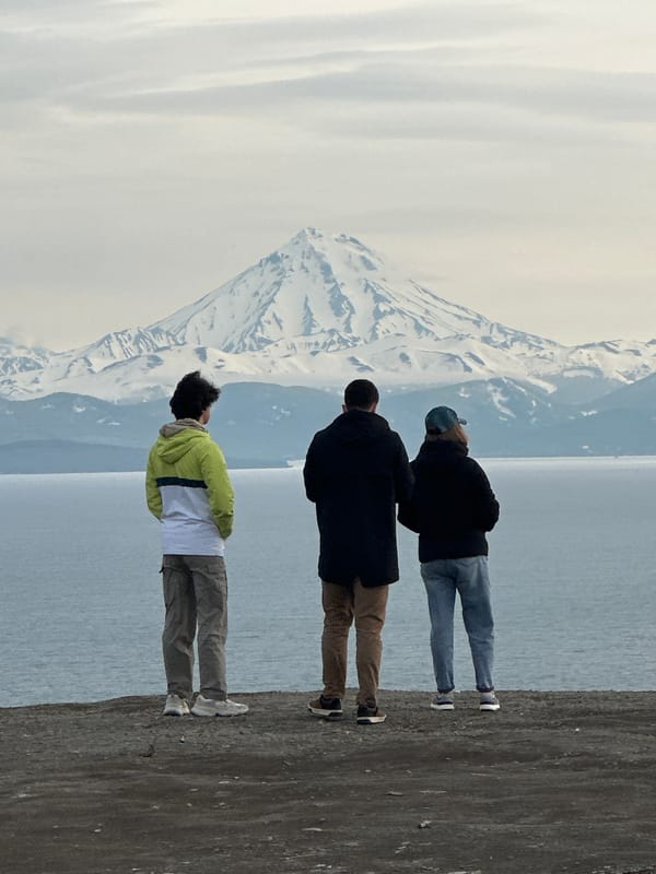Rocky coastal overlook facing Avacha Bay and Kamchatka's volcanic peaks