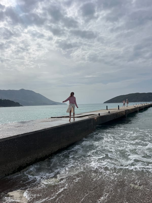 Woman poses on Budva pier during morning coastal visit