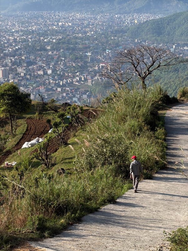Man in red cap walks roadside in Pokhara