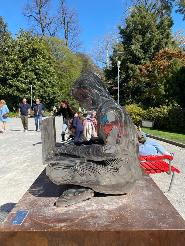 Toddler plays on public sculpture in Lugano lakeside park