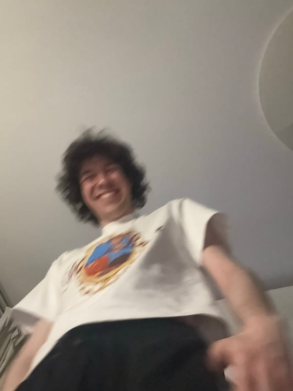 Casual indoor hang with headphones, laptop, and a graphic tee