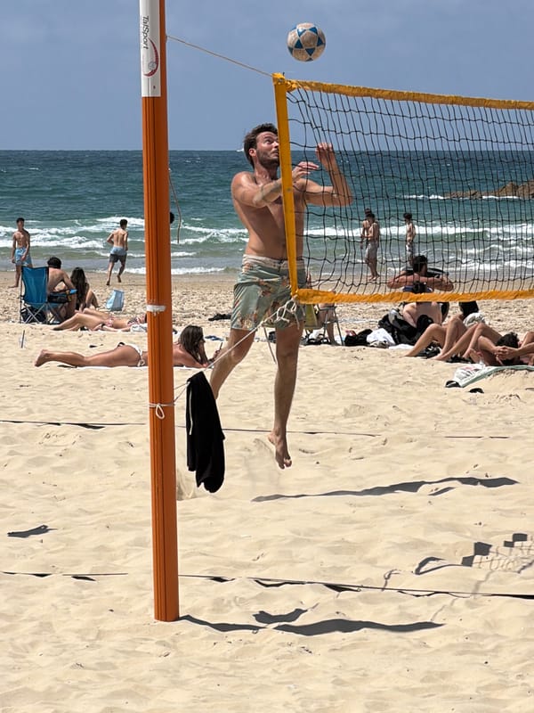 Morning beach scene documented in Tel Aviv with surfboard, beachgoer