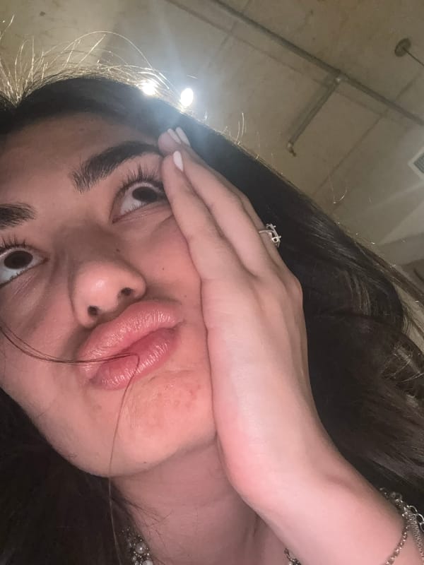 Person takes angled selfie with hand gesture in Milan