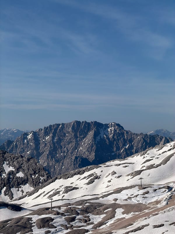 Snow-covered slopes and a ski lift pole in the Bavarian Alps.