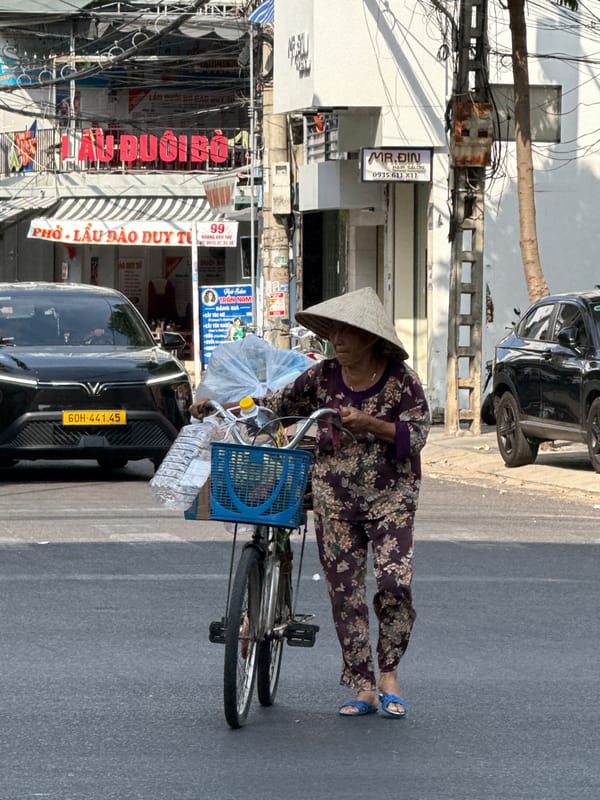 Elderly woman with bicycle, yellow car observed on Nha Trang street