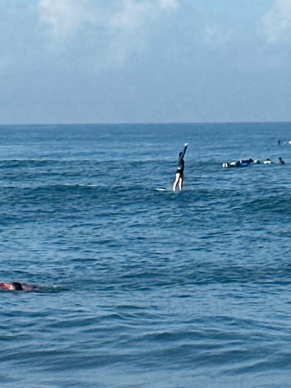 Kuta Beach surf session, boards in hand and waves breaking