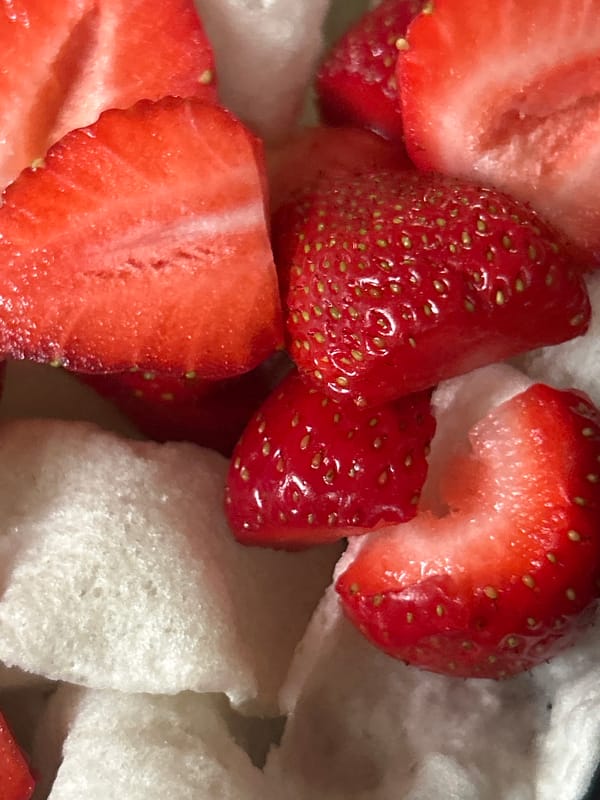 Strawberries and white crackers combined in black bowl snack