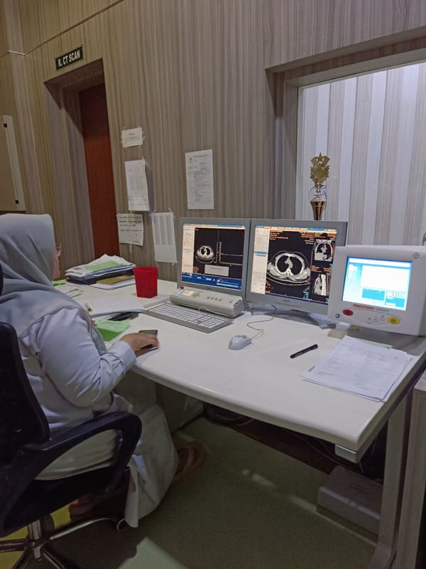 CT imaging session across workstation, scanner, and exam table